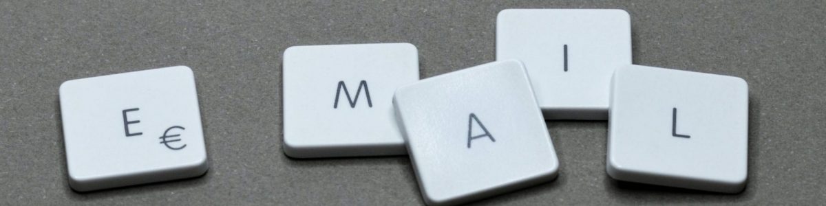 Close-up of the word 'email' formed with letter tiles on a gray surface.